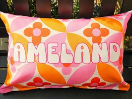 Sierkussen met retro bloemenpatroon in oranje en roze, Ameland-in wit-roze letters