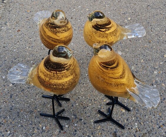 Vogel van bruin/goud glas op zwarte pootjes van metaal.