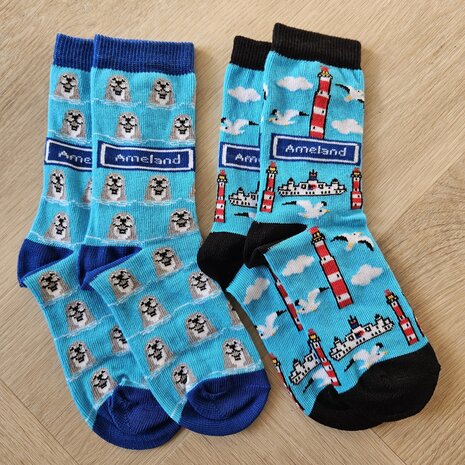 Lichtblauwe Ameland kindersokken met illustraties van de rood-witte vuurtoren, witte meeuwen en de veerboot of Zeehonden